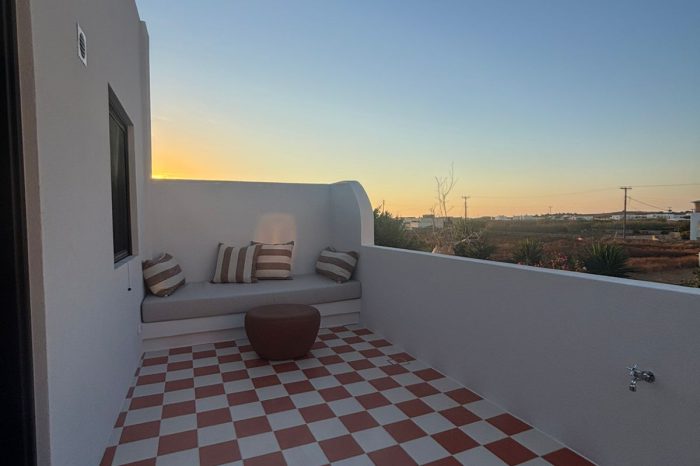 Private terrace with red-and-white checkerboard tiles and built-in bench at sunset, Bluewaves Antiparos Sunstone Terrace House