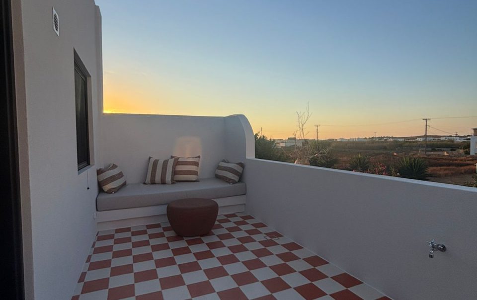 Private terrace with red-and-white checkerboard tiles and built-in bench at sunset, Bluewaves Antiparos Sunstone Terrace House