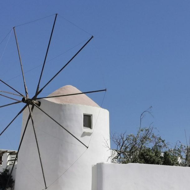 The whitewashed windmill at the entrance to Chora, Antiparos, against a clear blue sky